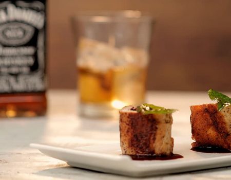 Rollos de cerdo rellenos con queso provolone y arándanos, en salsa para teriyaki y whiskey