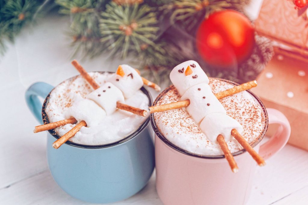 Dos posillos de chocolate con masmelos en forma de muñeco de nieve